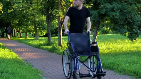 A man with an empty wheelchair 動画素材 77945375