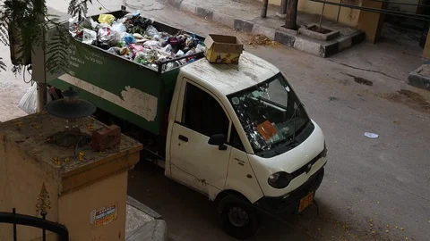 Man-emptying-garbage-into-a-garbage-truck Stock Footage 128409817