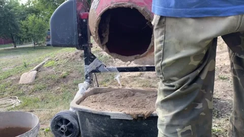 Man emptying mixed clay from concrete mixer Stock Footage 316539707