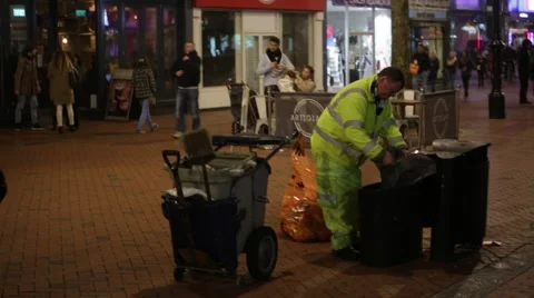 Man emptying trash in the evening, high street, England, Europe Video stock 58191822