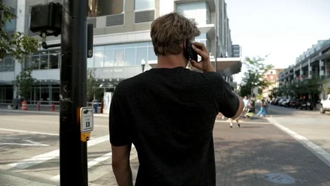 Man Ends Phone Call and Crosses Street Stock Footage 100034187