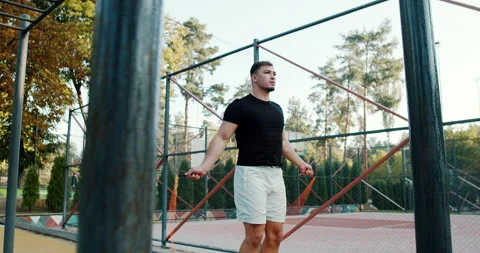 A man energetically jumping rope in a vibrant urban workout space surrounded by Stock Footage 317756787