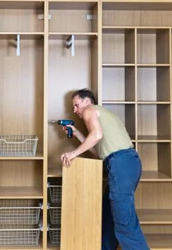 The man is engaged in assemblage of a new wardrobe Stock Photos