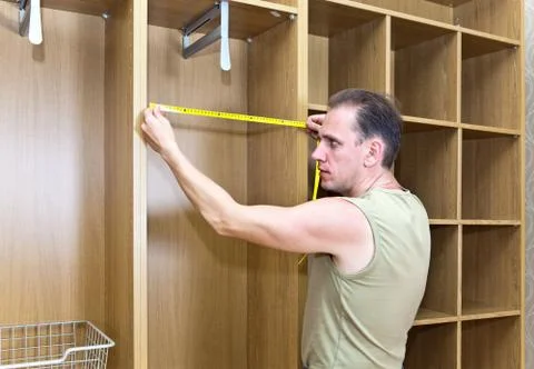 The man is engaged in assemblage of a new wardrobe Stock Photos