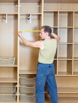 The man is engaged in assemblage of a new wardrobe.. Stock Photos