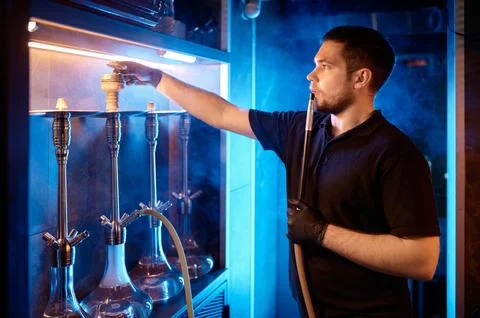 Man engaged in hookah preparation process Stock Photos