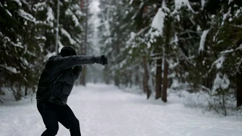 A man is engaged in kickboxing in the park, in the forest, in the early morning Stock Footage 229929938