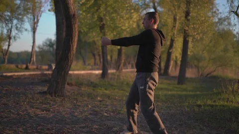 The Man is Engaged in Martial Arts,performs Kata Karate on the Sand Banks of Stock Footage 75156103