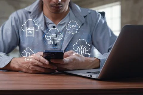 Man Engaged with Mobile Device Surrounded by Cloud Technology Icons Stock Photos