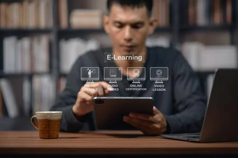 Man Engaged in Online Learning Using a Tablet in a Library or Study Area 스톡 사진