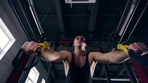 Man is engaged in trx exercises in the studio Stockbeeldmateriaal 75098385