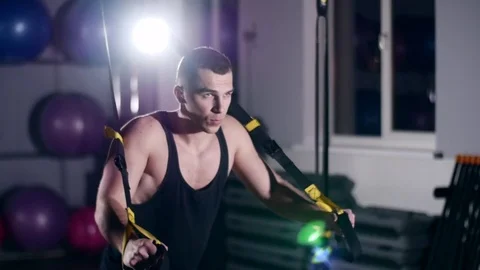Man is engaged in trx exercises in the studio Stock Footage 75099209