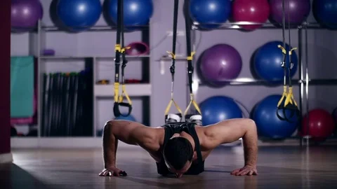 Man is engaged in trx exercises in the studio Stockbeeldmateriaal 75101453