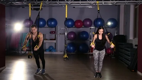 Man is engaged in trx exercises in the studio Stock Footage 76478022