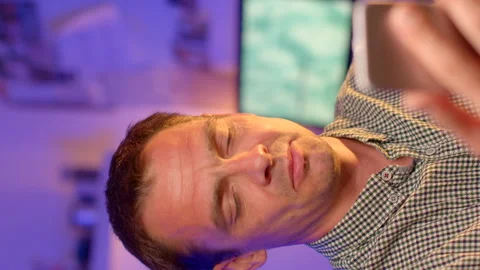 Man is engaged in a video call using his smartphone Fingers touch lips. Stock Footage 280463837