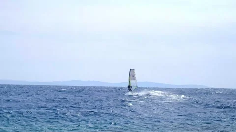 A man is engaged in windsurfing in the red sea, mountains in the background, wat Stock-Footage 240199341