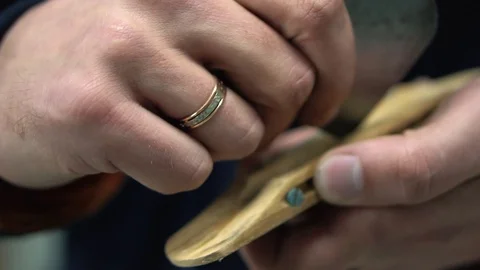 Man with an engagement ring on his hand processes with a help of a grinding Video stock 73910333