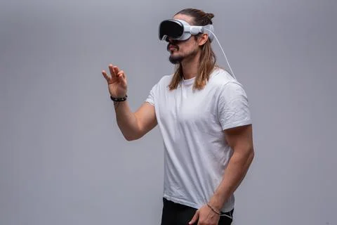 Man engages with a virtual world using a mixed reality spacial computer headset Stock Photos