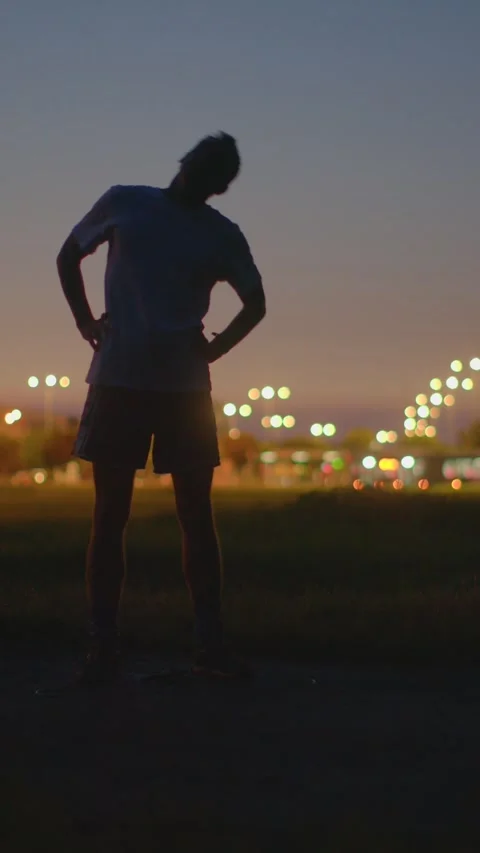 Man engaging in various stretches during evening at park before cardio activity Stock Footage 334119810