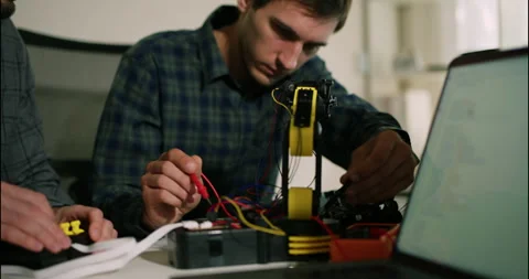 Man Engineer Assembling and Wiring Robotic Arm Prototype. Stock Footage 306737025