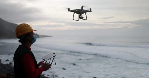 Man engineer flying with drone while wearing protective mask Vídeos de archivo 145430722