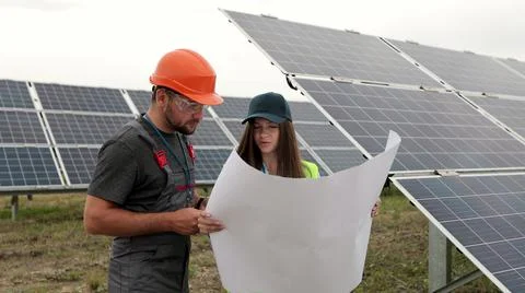 Man engineer in hard hat and inspector engineer woman learning the paper plan Stock Photos