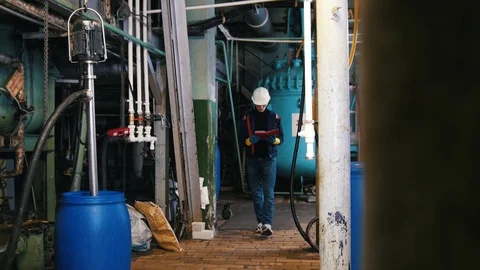A man engineer in manufacturing plant. Walking around the plant Stock Footage 102956412