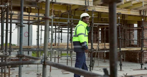 Man, engineer or phone call at scaffolding for discussion, compliance update or Stock Footage 337634688