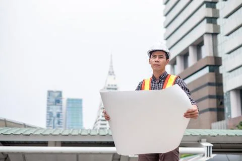 Man engineer standing open blueprint with looking be concentrated Stock Photos