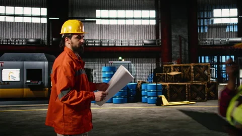 Man engineer, studying blueprints, sketches and layout plans, machinery hall Stock Footage 330089734