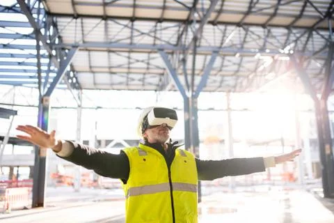 Man engineer using VR goggles on construction site. Stock Photos