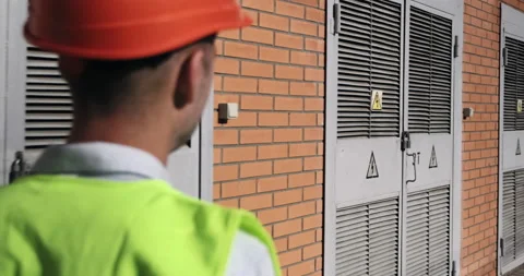 Man engineer walks past electricity production substation Vídeos de archivo 160987867