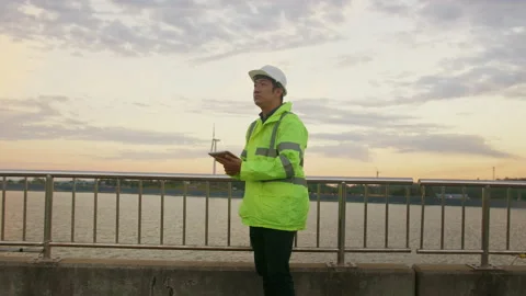 A man engineer is wearing a protective helmet on her head, using tablet Analy 動画素材 169238911