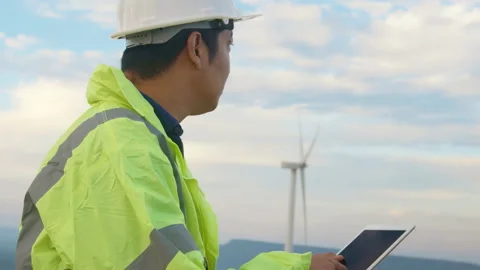A man engineer is wearing a protective helmet on her head, using tablet Analy Vídeo Stock 169239153
