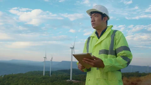 A man engineer is wearing a protective helmet on her head, using tablet Analy Vidéo 169239240