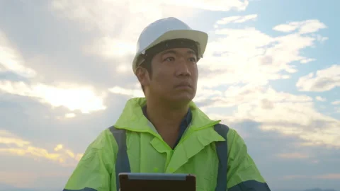 A man engineer is wearing a protective helmet on her head, using tablet Analy Stock-Footage 169239407