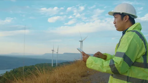 A man engineer is wearing a protective helmet on her head, using tablet Analy Video stock 169239751