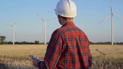 Man engineer at work is wearing a white protective helmet and taking notes with Stock-Fotos