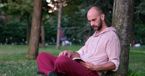 Man enjoying a book in the park Stock Footage 247016531