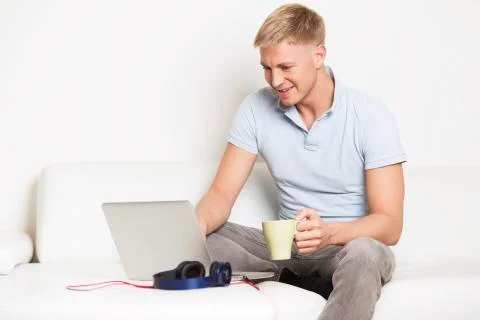Man enjoying a cup of coffee while working on computer. Stock-Fotos