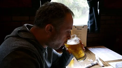 Man is enjoying drinking on draft beer from a glass at the bar Stock Footage 96048366
