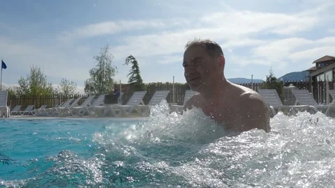 Man enjoying hydro therapy refreshing in swimming outdoor spa pool with splas Video stock 330694463