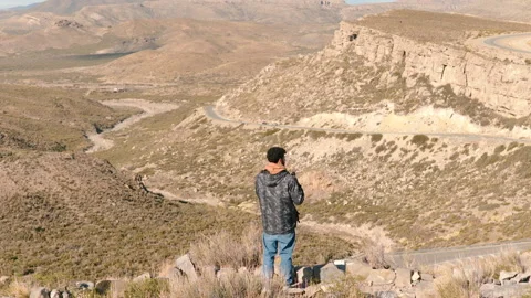 Man Enjoying Mate on Mountain Overlooking Winding Road Stock Footage 336035889