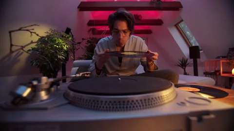 Man enjoying music while handling vinyl records in cozy indoor setting Stock Footage 319959669