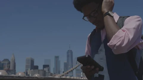Man enjoying music while standing near city skyline on a sunny day Stock-Footage 312640919