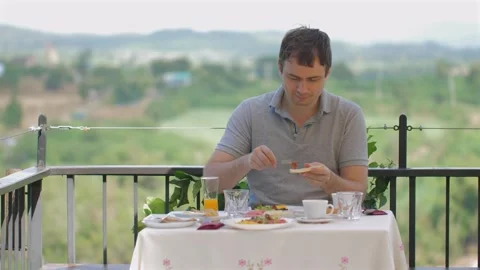 Man enjoying outdoor dining experience alone at scenic restaurant with Видео 276178352