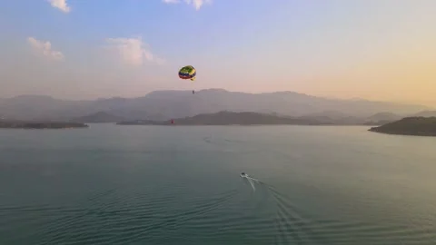 Man enjoying a para sailing flight at beach during sunset with beautiful Stock Footage 181926092