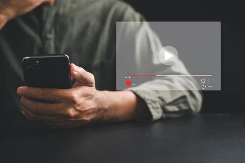 Man enjoying video streaming on virtual screen with a smartphone Stock Photos