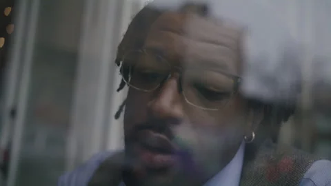 Man enjoying a warm drink while gazing out the window in the city Stock Footage 312473149