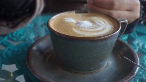 Man enjoys coffee in a cafe with decorative blue table at afternoon Stock Footage 345625014